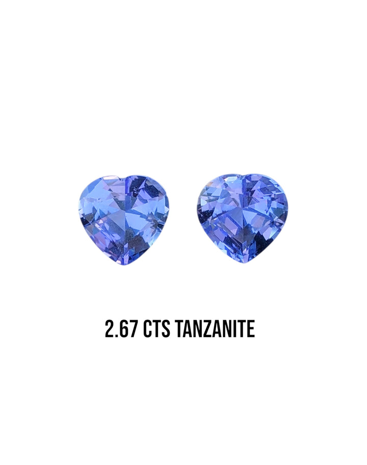Two heart-shaped tanzanite gemstones with a weight of 2.67 carats on a white background.